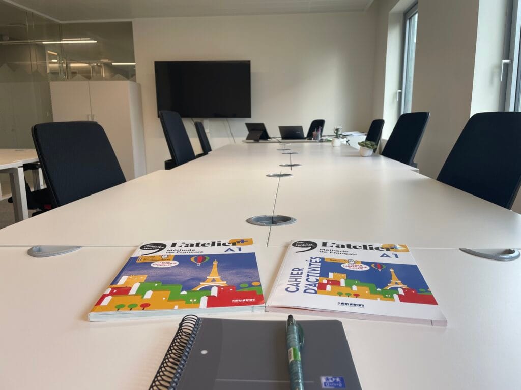 FTC Paris French classroom with student activity books, modern desk setup, and ergonomic seating