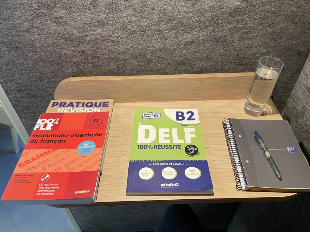 French textbooks for DELF B2 exam and grammar revision in a quiet study booth at FTC Paris