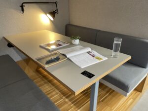 Cosy study table with L’atelier+ textbook and notes, in a shared quiet workspace at FTC Paris